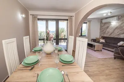 a dining room with a table with green plates at Guest House Luksic in Bar