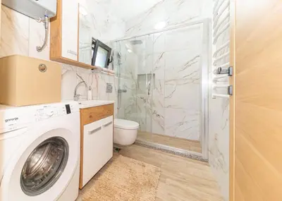 a bathroom with a washing machine and a shower at Guest House Luksic in Bar