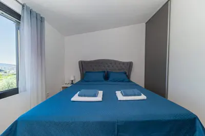 a bedroom with a blue bed with two towels on it at Guest House Luksic in Bar