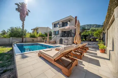 a backyard with a swimming pool and a house at Guest House Luksic in Bar