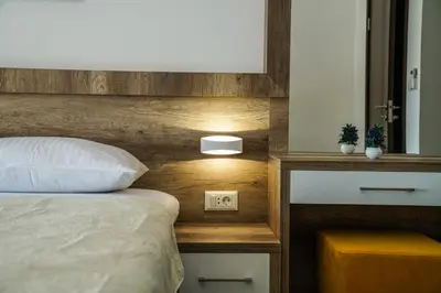 a bedroom with a bed with a wooden head board at BUZUKU Apartments Liman (Mediterraneo) in Ulcinj