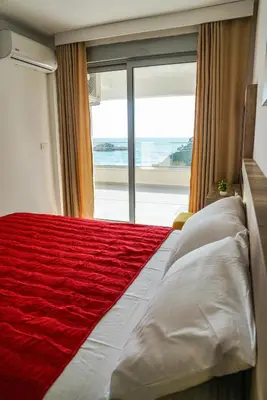 a bedroom with a large bed with a large window at BUZUKU Apartments Liman (Mediterraneo) in Ulcinj