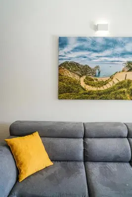 a couch in a living room with a painting on the wall at BUZUKU Apartments Liman (Mediterraneo) in Ulcinj