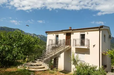 a white building with stairs and a balcony at Plamenatz studio apartments in Virpazar