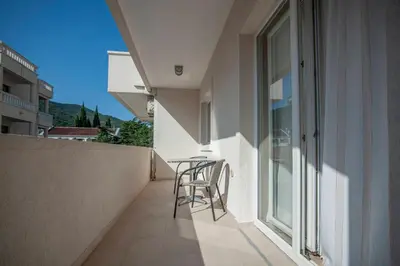 a balcony with chairs and a table on the side of a building at Mandir apartments - Center in Budva