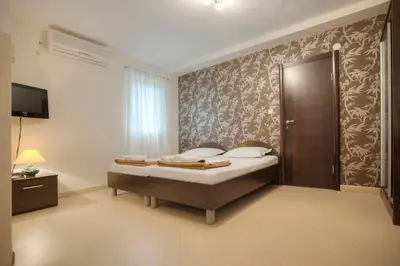 a bedroom with a bed and a wall at Mandir apartments - Center in Budva