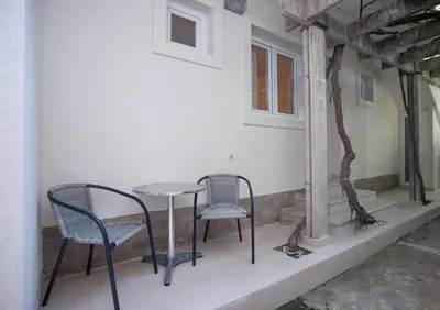 two chairs and a table on the porch of a house at Mandir apartments - Center in Budva