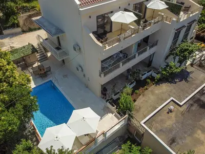 an aerial view of a house with a swimming pool and umbrellas at Square Point Apartments in Kotor
