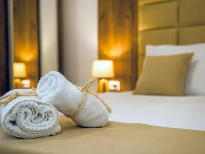 a hotel room with a rolled up towel on a bed at Square Point Apartments in Kotor