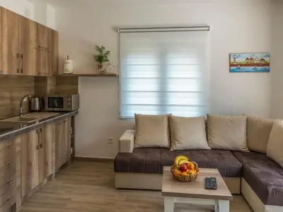 a living room with a couch and a table with a bowl of fruit at Square Point Apartments in Kotor
