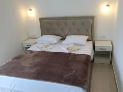 a bedroom with a large white bed with two pillows at Apartments Raskovic I in Radanovići