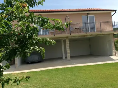 a house with a balcony and a garage at Apartments Raskovic I in Radanovići