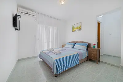 a bedroom with a bed and a television in it at Apartment Dragicevic 2 with Garage in Budva