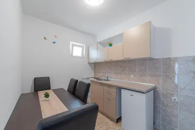 a kitchen with a table and chairs in a room at Apartment Dragicevic 2 with Garage in Budva