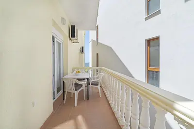 a balcony with a table and chairs on it at Apartment Dragicevic 2 with Garage in Budva