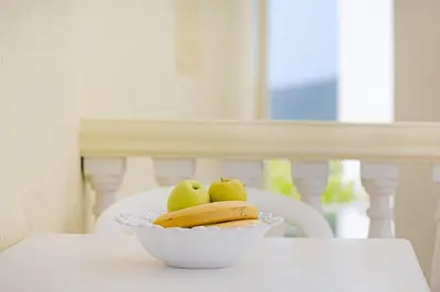 a bowl of apples and bananas on a table at Apartment Dragicevic 2 with Garage in Budva