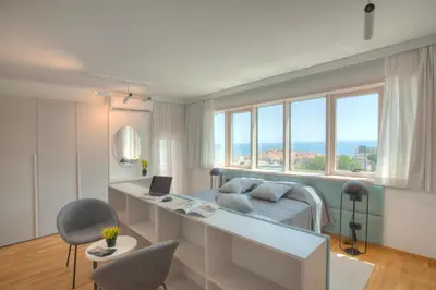 a bedroom with a bed and a desk with a laptop at Fontana Seafront Residences in Budva