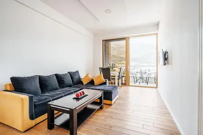 a living room with a blue couch and a table at Victoria Top View in Budva