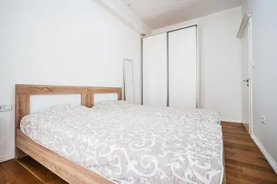 a bedroom with a bed with a white comforter at Victoria Top View in Budva