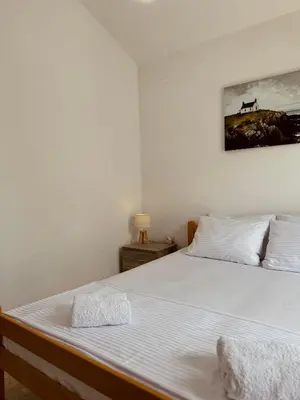 a bedroom with a bed with white sheets at Apartmani Sara in Ulcinj
