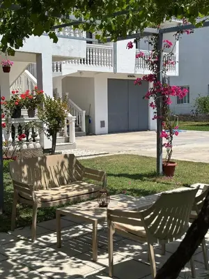 two chairs and a bench in front of a house at Apartmani Sara in Ulcinj
