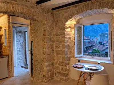 a small table in a room with a window at Romantic Rooftop View Hideaway- Old Town Nr 404 in Kotor