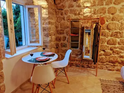 a table and chairs in a room with a stone wall at Romantic Rooftop View Hideaway- Old Town Nr 404 in Kotor