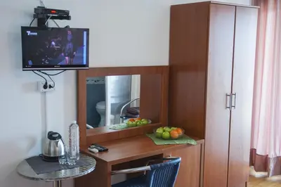 a room with a desk with a mirror and a tv at Axenia Hotel in Utjeha
