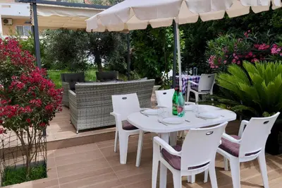a white table and chairs under an umbrella on a patio at Axenia Hotel in Utjeha