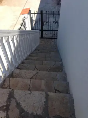 a stairway with a white fence and a stone staircase at Axenia Hotel in Utjeha
