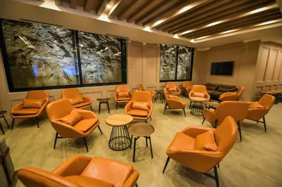 a waiting room with orange chairs and tables at Plaza Hotel&SPA in Ulcinj