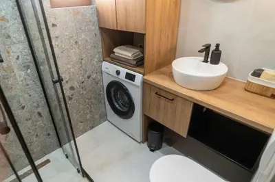 a bathroom with a sink and a washing machine at Green Hill in Virpazar