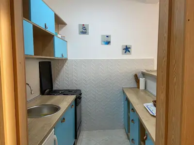 a small bathroom with blue cabinets and a sink at Apartment Hanja in Bar