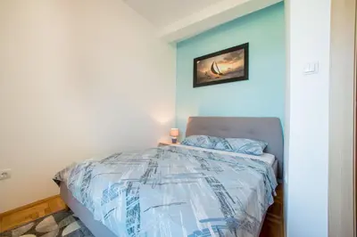 a bedroom with a bed with a blue wall at Apartment Hanja in Bar