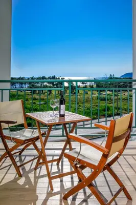 a table with two chairs and a wine glass on a balcony at Apartment Hanja in Bar