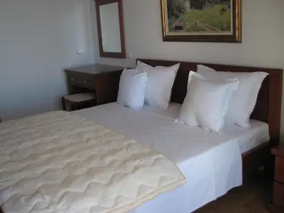 a bedroom with a bed with white sheets and pillows at Apartments Leut in Sveti Stefan