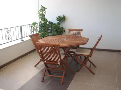 a wooden table and chairs sitting on a balcony at Apartments Leut in Sveti Stefan
