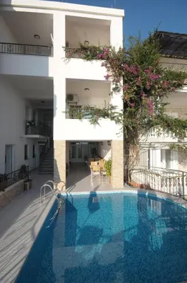 an apartment with a swimming pool in front of a building at Apartments Leut in Sveti Stefan