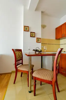 a kitchen with a wooden table and two chairs at Apartments Leut in Sveti Stefan