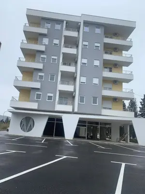 a building with a parking lot in front of it at Apartment All Seasons in Ulcinj
