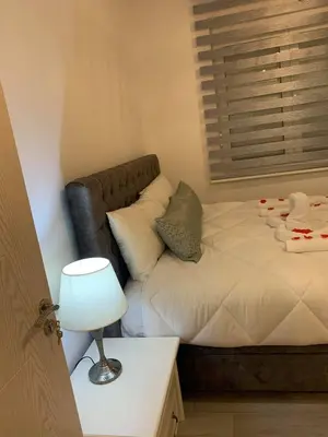 a small bedroom with a bed and a lamp at Apartment All Seasons in Ulcinj