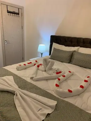 a bed with white sheets and red hearts on it at Apartment All Seasons in Ulcinj