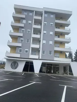 a large building with a parking lot in front of it at Apartment All Seasons in Ulcinj