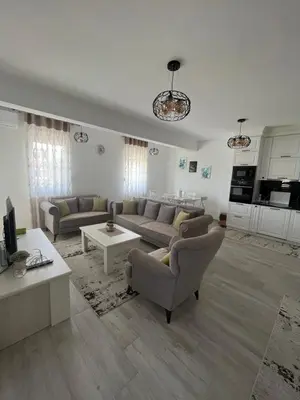 a living room with two couches and a kitchen at Apartment All Seasons in Ulcinj