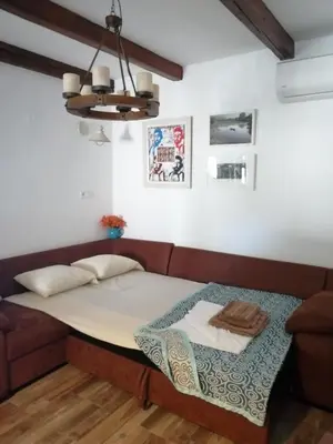 a bed in a room with a couch at Etno house HAPPY VILLAGE in Cetinje