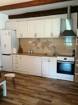 a kitchen with white cabinets and a sink and a refrigerator at Etno house HAPPY VILLAGE in Cetinje