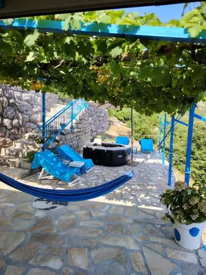 a patio with blue chairs and a fire pit at Etno house HAPPY VILLAGE in Cetinje