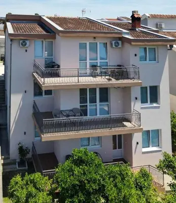 an apartment building with balconies and trees at Kasneci Apartments in Ulcinj