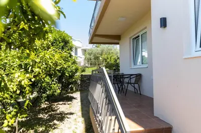 a balcony of a house with a table and chairs at Kasneci Apartments in Ulcinj