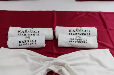 a bed with two white towels on top of it at Kasneci Apartments in Ulcinj